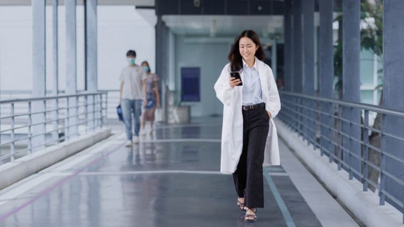 Doctor Walking In Hospital Using Phone